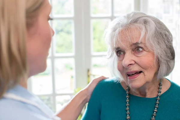 Vård Arbetstagare Talar Till Senior Kvinna Hemma — Stockfoto