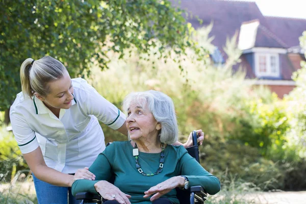 Φροντιστής Πιέζει Ανώτερων Γυναίκα Αναπηρικό Καρότσι Κήπου — Φωτογραφία Αρχείου