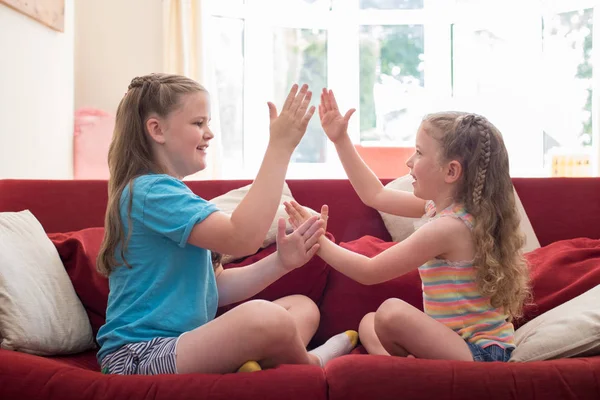 Two Sisters Sitting Sofa Playing Clapping Game Together — Stock Photo, Image