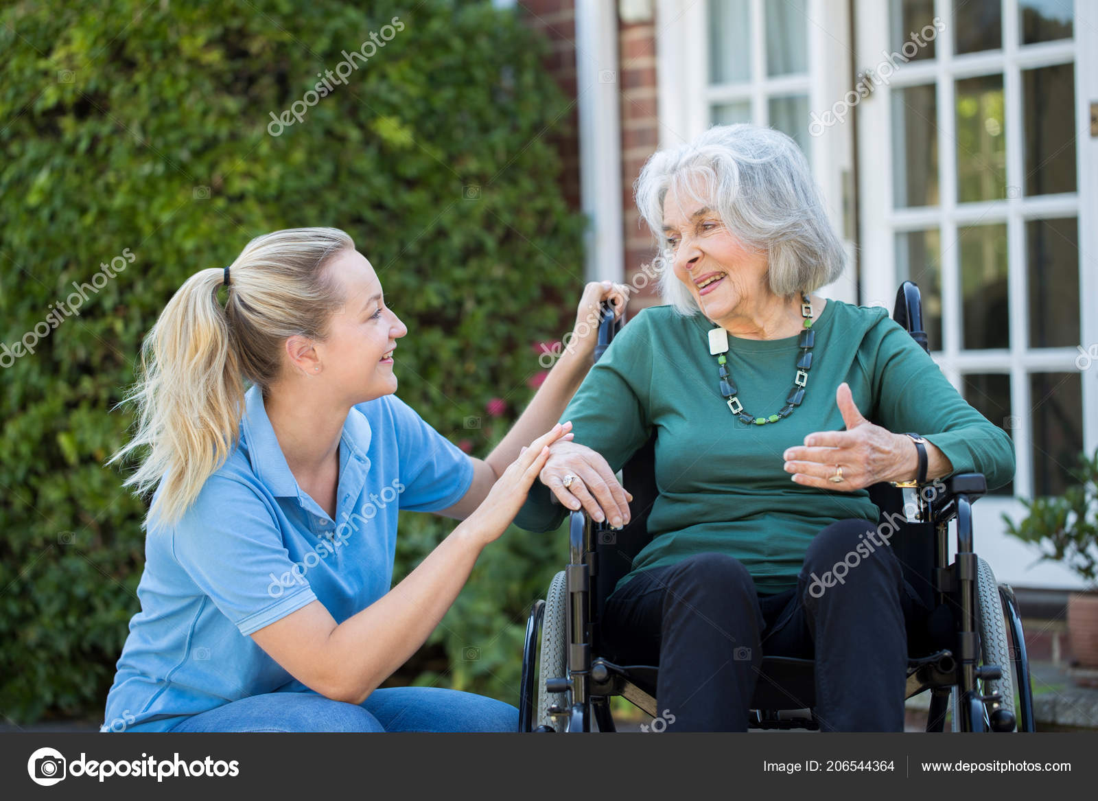 Carer Pushing Senior Woman Wheelchair Home Stock Photo by ©daisydaisy