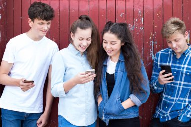Grup Genç Froends cep telefonları kentsel ortamda bakarak