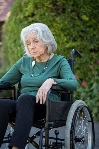 坐在户外轮椅上的忧郁的资深妇女 — 图库照片