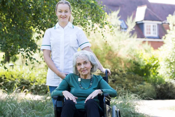 Portrait Carer Pushing Senior Woman Wheelchair Home — стоковое фото
