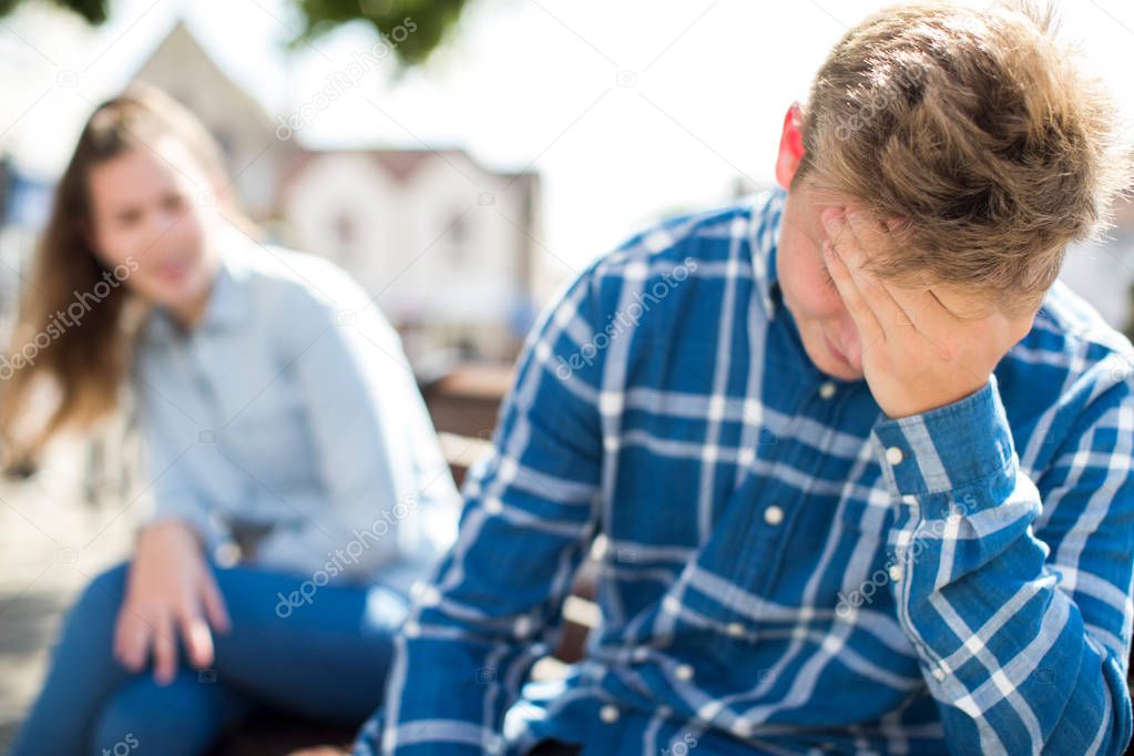 Unhappy Teenage Couple Having Argument In Urban Setting