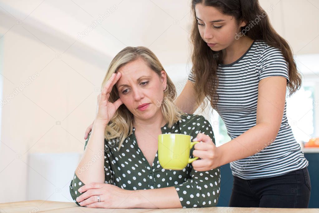 Teenage Daughter Making Drink For Parent Suffering With Mental Health Problems