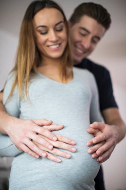 Adam evde hamile kadının karnına eller dinlenme