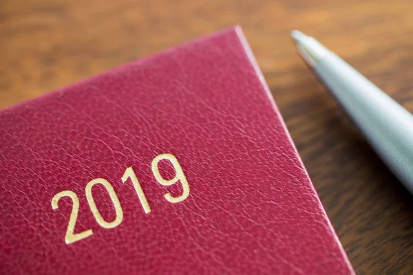 2019年关闭日记与钢笔在木办公桌上 — 图库照片