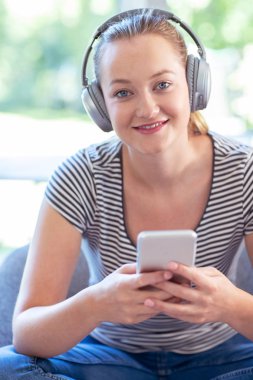 Ev müzik akışı cep telefonundan kablosuz kulaklıklar için kadın portresi
