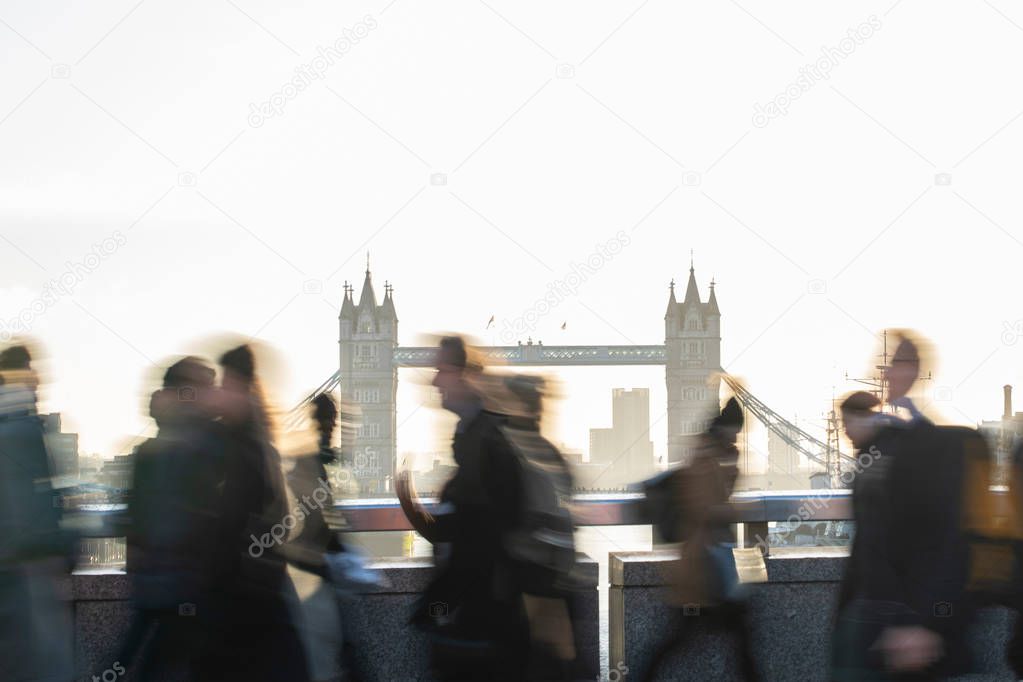 Motion Blur Shot Of Commuters Walking To Work Across London Bridge UK With Tower Bridge In Background