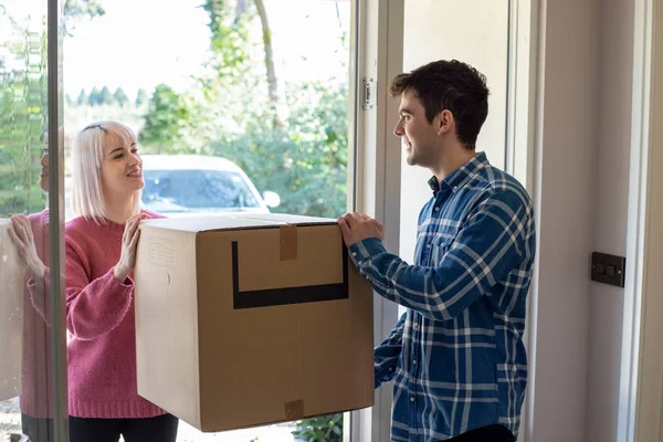 Jong koppel uitvoering vakken naar nieuw huis over het verplaatsen van de dag — Stockfoto