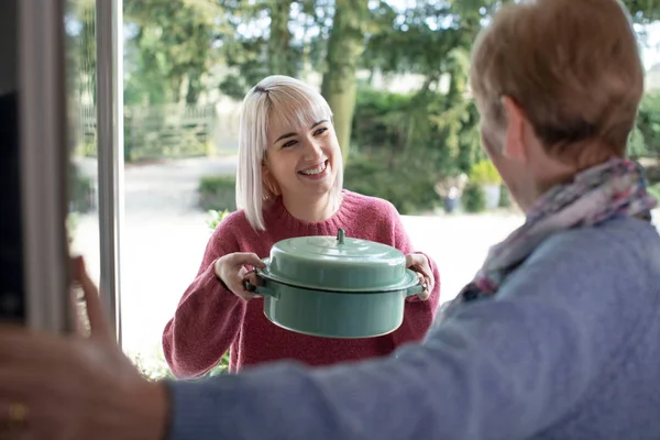 Woman Bringing Meal For Elderly Neighbour — Stock Photo, Image