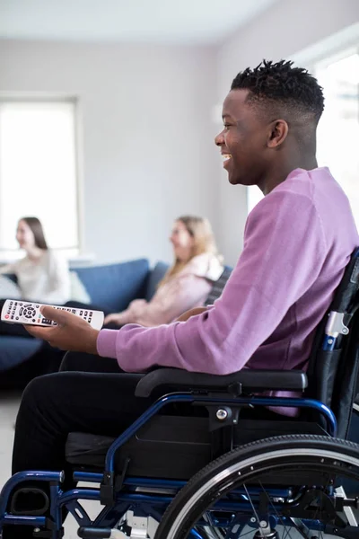 Genç çocuk Freinds Ho, televizyon izlerken tekerlekli sandalyede — Stok fotoğraf