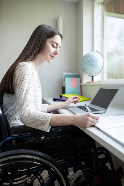 Teenager-Mädchen im Rollstuhl lernt zu Hause am Laptop — Stockfoto