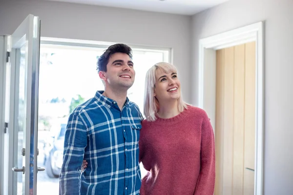 Casal jovem olhando em torno de casa nova para alugar ou comprar juntos — Fotografia de Stock