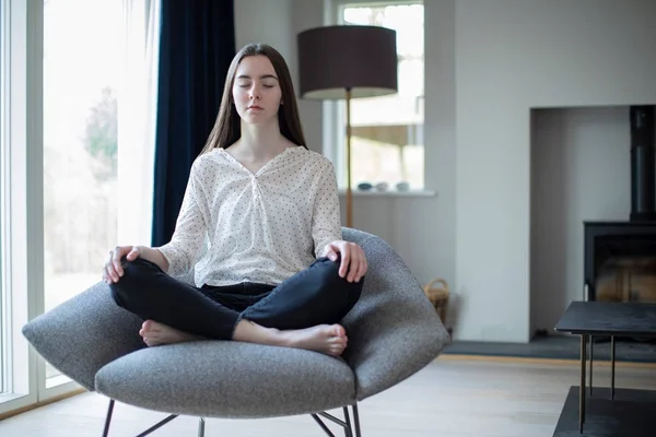 Pokojowy nastolatek dziewczyna medytacja siedzi w fotelu w domu — Zdjęcie stockowe