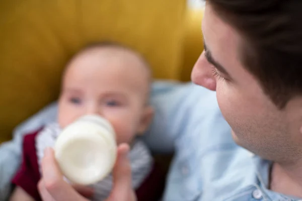 Gros plan de l'amour nourrissant bébé fils avec bouteille à la maison — Photo