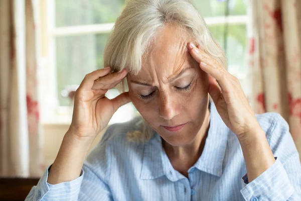 Старшая женщина дома страдает от мигрени — стоковое фото