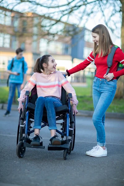 Adolescente chica en silla de ruedas hablando con amigo como ellos dejar Hig —  Fotos de Stock