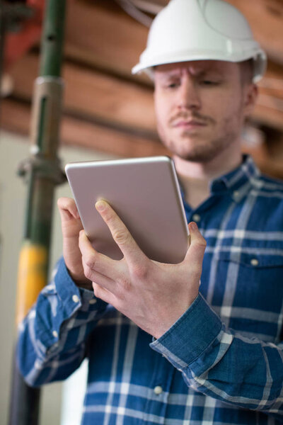 Architect Inside House Being Renovated Using Digital Tablet