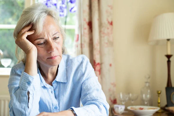 Senior kvinna som lider med depression med huvudet i händerna på Hom — Stockfoto