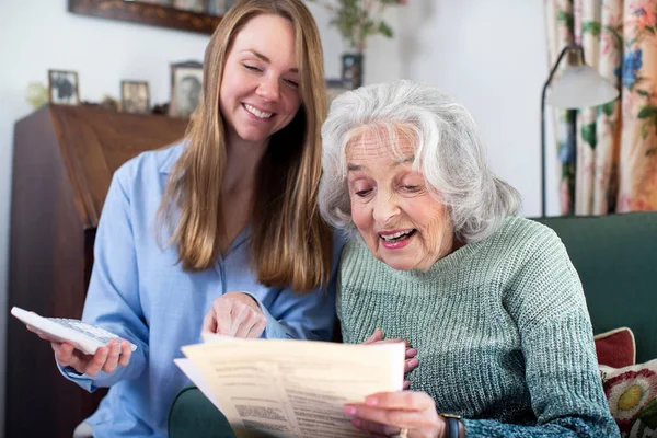 妇女帮助老年邻居处理账单和文件 — 图库照片