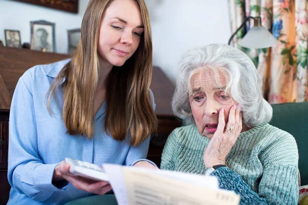 Kvinnan hjälper oroliga äldre granne bekymrad över skuld med — Stockfoto