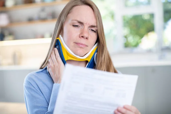 Mulher em casa Leitura carta depois de receber lesão no pescoço — Fotografia de Stock