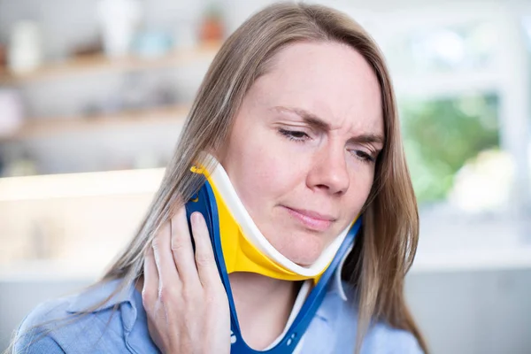 Vrouw dragen nek Brace Thuis Winces met pijn — Stockfoto