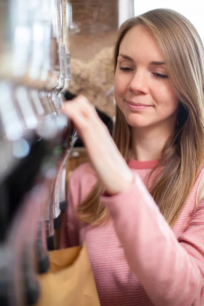 Frau füllt Papiertüte aus Spender für Getreide und Getreide in — Stockfoto