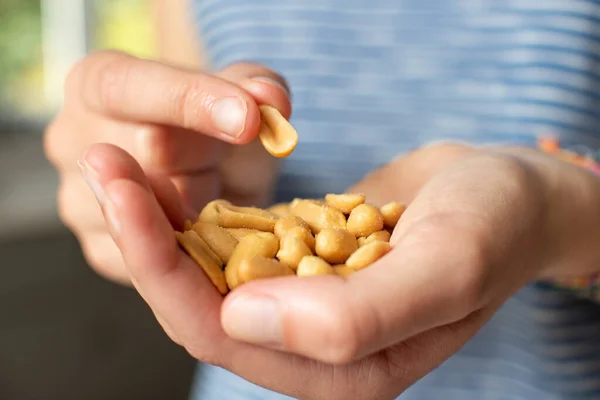 Close Teenage Girl Eating Handful Salted Peanuts — стоковое фото