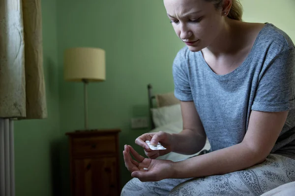 Γυναίκα Κάθεται Στο Κρεβάτι Φορώντας Πιτζάμες Λαμβάνοντας Φαρμακευτική Αγωγή — Φωτογραφία Αρχείου