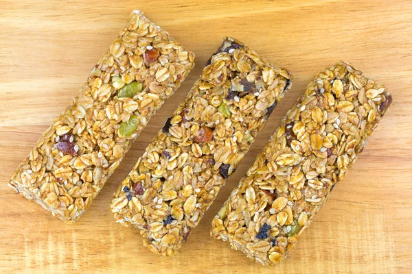 Fruit and nut muesli bar, healthy snack with source of fibre, high in whole grain, no artificial color or flavor, on wood background