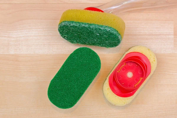 Old used and unused new dish washing heavy duty sponge with quick and easy refill clip on, on wooden background, top view with copyspace