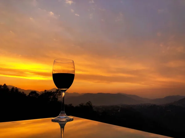 Copo de vinho tinto durante o pôr do sol sobre a cordilheira do Himalaia no Nepal — Fotografia de Stock