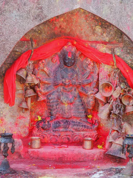 Metal bells offered by devotees at Kali Temple. Shrine full of red pigment powder — Stock Photo, Image