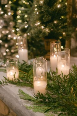 Yumuşak mum ışığı yemyeşil ortamda parlar, kapalı bir ortamda tatil kutlamalarının samimi atmosferini güçlendirir..