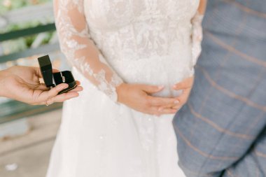 Bir el, müstakbel geline romantik bir açık havada göbeğini sallarken bir nişan yüzüğü sunar..