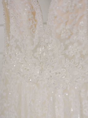 Zarif nakışlarla süslenmiş göz kamaştırıcı bir gelinlik ve hafif aydınlatmayla sergilenen parıldayan boncuklar..