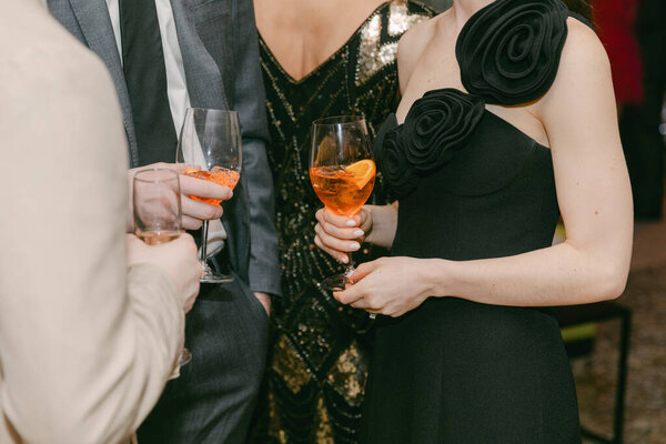 Участники общаются во время проведения красочных коктейлей на стильном вечернем мероприятии с элегантной одеждой и декором.