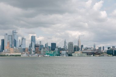 Bulutlu bir günde New York şehrinin ufuk çizgisi Hudson Nehri boyunca önemli binalar barındırıyor..