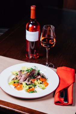 masada akşam yemeği, salata, pembe şarap kadehi, şişe