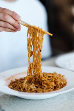 Bir pirinç kase üzerinde çubukları tutarak adam elinin seçilmiş odak. Chopsticks Çin, Japonya, Kore gibi çeşitli Asya ülkelerinde kullanarak ünlüdür