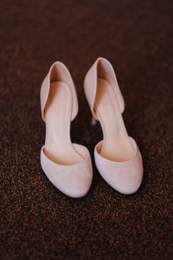 Kahverengi bir halı üzerinde gelinin Tasarımcı düğün beyaz ayakkabı. 
