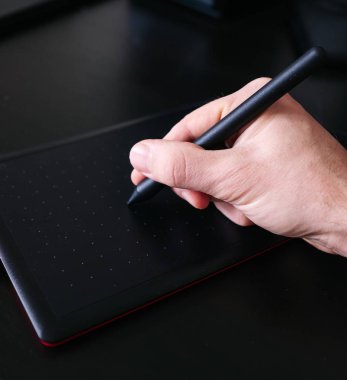 Grafik tabletinde çalışan bir erkeğin yakın plan fotoğrafı. Seçici odak.