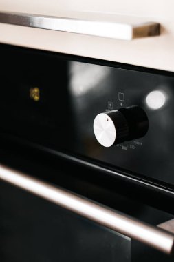 Düğme, gri arka planda beyaz bir gaz ocağını açıyor.