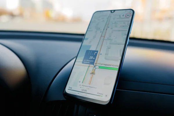 W widoku deski rozdzielczej samochodu ze smartfonem pokazującym mapy Yandex, aby pokazać drogę przez — Zdjęcie stockowe