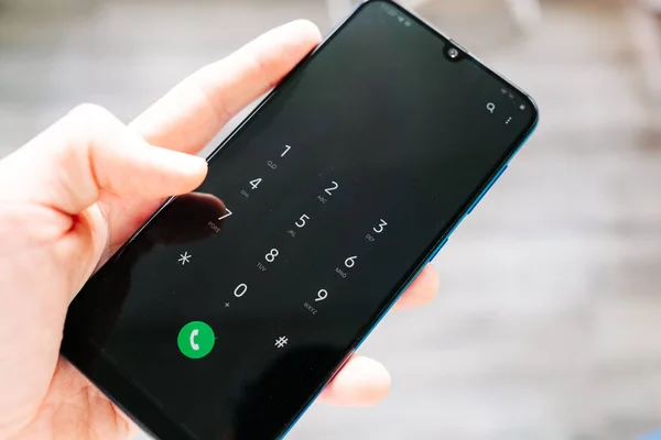 Ekranda çağrı numarası olan akıllı telefon erkek eli