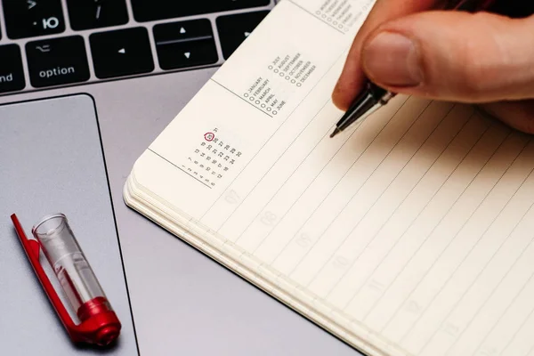 Male hand encircles date 25 (twenty five) in the diary calendar. — Stock Photo, Image