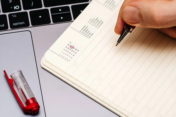 Male hand encircles date 27 (twenty seven) in the diary calendar. — Stock Photo, Image