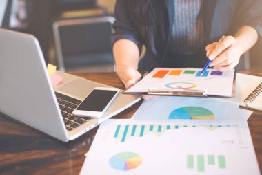 Çizelgeler ve grafikler sonuçları gösterilen tartışırken işadamı analiz çalışma.